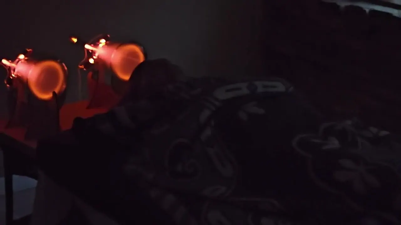 Two Theraphi plasma tubes glowing amber beside a guest resting under a blanket